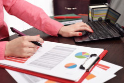 woman checking budget or payroll with laptop